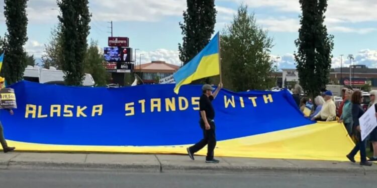 Një 'frymë' larg takimit në Alaskë, disa njerëz protestojnë duke valëvitur flamujt e Ukrainës.