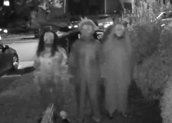 Pamje shqetësuese para shtëpisë, ku tre individë të masked kërcënojnë me vdekje një grua dhe fëmijët e saj.