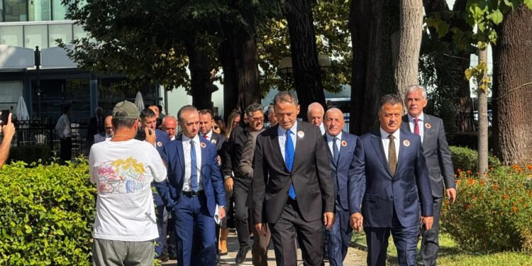 Deputetët e PD-së me stemën e UÇK-së në kostume i drejtohen Kuvendit dhe vendosin foton Ballukut në dyert