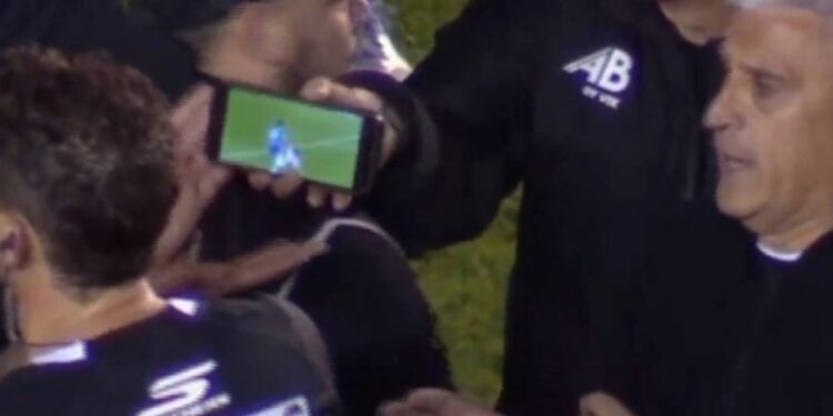 Lojtarët tregojnë videon në telefon, arbitri ndryshon vendimin pas 26 minutash kaos