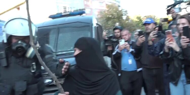 Mbështes të rinjtë: E moshuara e maskuar godet efektivët me shkop gjatë protestës